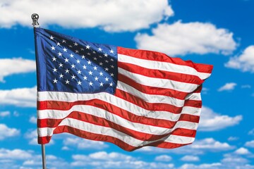 Waving American flag on a flagpole at blue sky © BillionPhotos.com