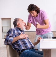 Fototapeta premium Young student and his old grandpa at home