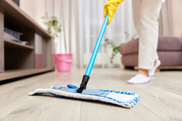 young woman cleaning and mopping floor at living room, daily housekeeping , close-up
