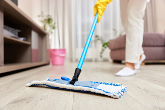 young woman cleaning and mopping floor at living room, daily housekeeping , close-up