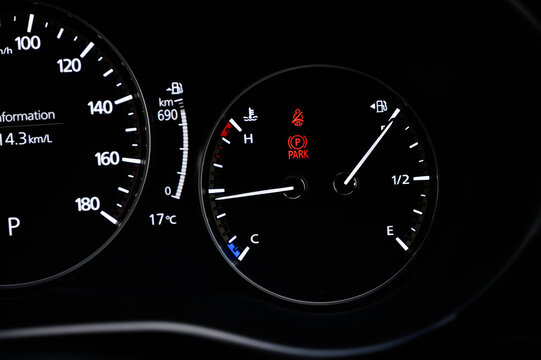 Detail with the fuel gauges and engine temperature showing and tank on full a bucket dashboard of car.