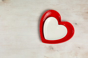 Heart shaped plates on white wooden background. Top view. - 715845341