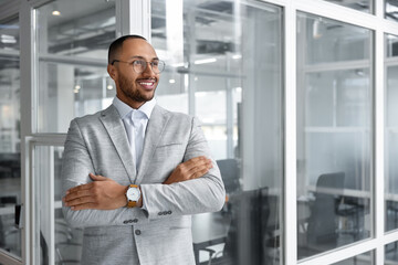 Fototapeta premium Happy man with crossed arms in office, space for text. Lawyer, businessman, accountant or manager