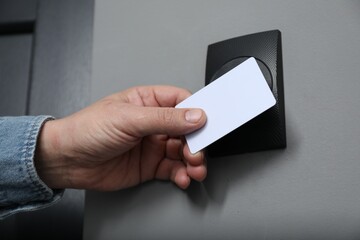 Man opening magnetic door lock with key card, closeup. Home security