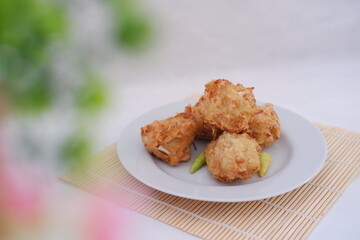 Bakwan sayur or vegetable fritter, Indonesian snack made from flour, cabbage, carrots and bean sprouts, served with chili