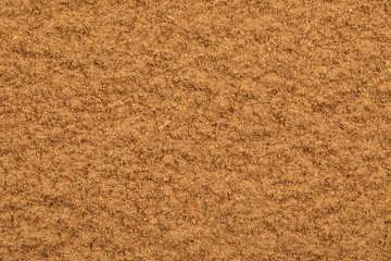 Dry aromatic cinnamon powder as background, top view