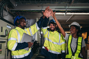 Fototapeta premium Team engineers and foreman stack hand and shake hands to show success at inverter solar panel room. Worker industry join hand for collaboration.