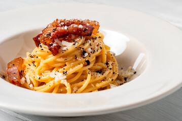 Piatto di deliziosi spaghetti alla gricia, una tradizionale ricetta della cucina romana di pasta...