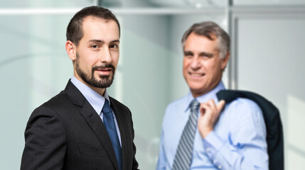 Professional partnership: young and senior businessmen at office