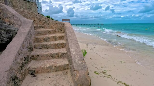 Escaleras de piedra que terminan en el mar caribe color turquesa, playa con arena blanca