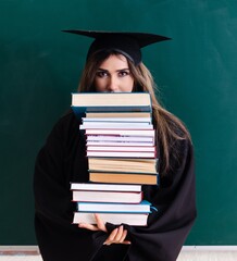 Female graduate student in front of green board