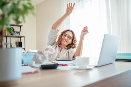Beautiful joyful middle-aged woman in glasses extremely glad with new higher taxes and throwing bills UP. Small business troubles, bull market or money savings concept image