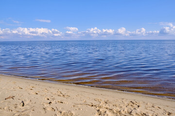 Blue sea and white clouds on sky.