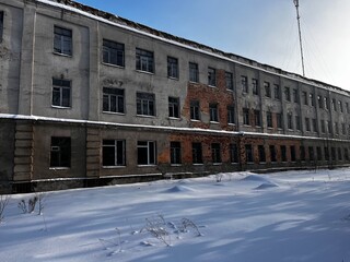 Fototapeta premium Old abandoned factory building in winter.