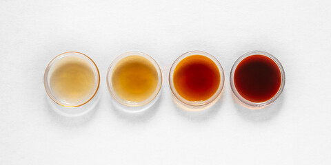 Different classes of maple syrups in different colours in glass dishes