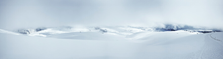 Fototapeta na wymiar winter landscape of snow-capped mountains with a surreal blue-white atmosphere
