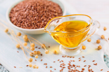 Brown linen seeds, flaxseed vegetable oil on white wooden background. Healthy super food