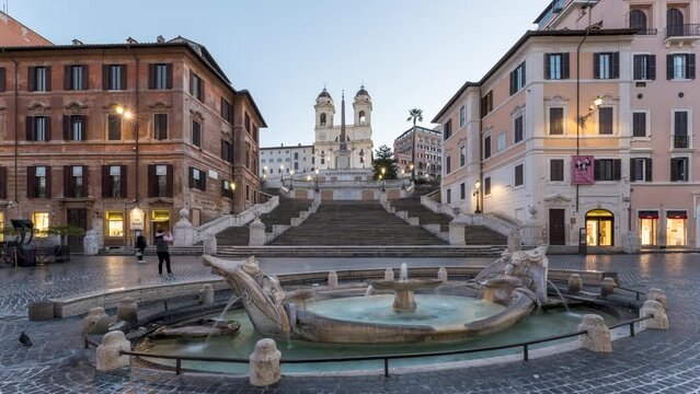 Timelapse of the famous Spanish steps with fountain and illuminated streetlights during blue hour in Rome, Italy