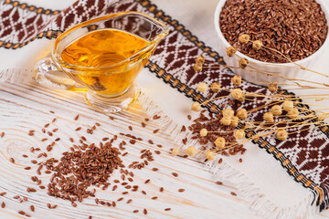 Brown linen seeds, flaxseed vegetable oil on white rustic wooden background. Healthy super food