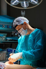 Plastic surgeons perform surgery on a patient