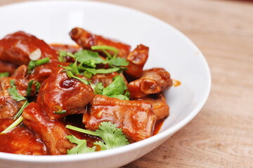 Chinese Red Soup Pork Ribs served on a white plate, a popular Chinese dish, made from sliced pork ribs and tomato sauce.