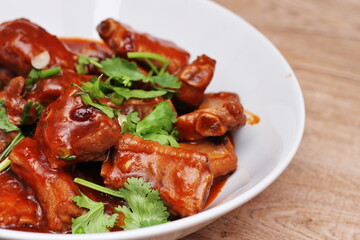Chinese Red Soup Pork Ribs served on a white plate, a popular Chinese dish, made from sliced pork ribs and tomato sauce.