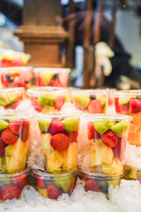 Assorted fresh fruit cups on ice, offering a colorful mix of healthy, ready-to-eat options.