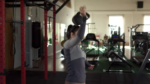 Woman having fitness training with kettlebell in sport. Fitness, workout, gym exercise and healthy