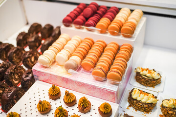 Artful pastries with piped cream and pistachio on a display counter.