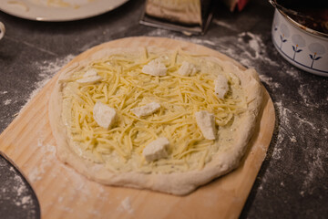 Home made white pizza, great dough with cheese, mozzarella and other components of a good white pizza. Pizza waiting to be put in an oven