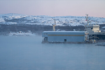 Vista de nave en el agua del mar en Kirkenes en Noruega tras el que hay un barco
