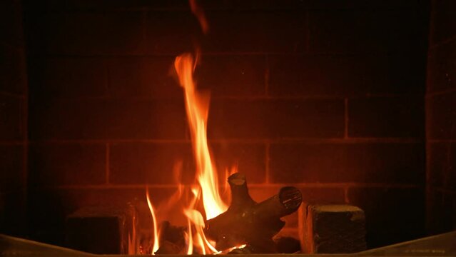 Home cozy fireplace with red flame and birch firewood. 4K video relaxing endless footage 