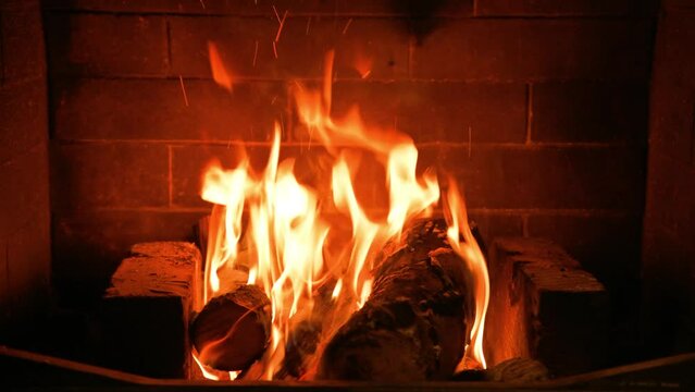 Home cozy fireplace with red flame and birch firewood. 4K video relaxing endless footage 