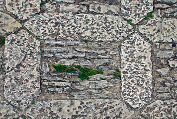 Close-up view of typical cobblestone in small mountain village Erice, Sicily, Italy. Medieval stone street. Stone pattern, cobblestone texture. Background of stone pathway texture.