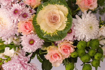 Bouquet of flowers with pink roses, brassica flower, chrysanthemum and freesia flower in a vase.