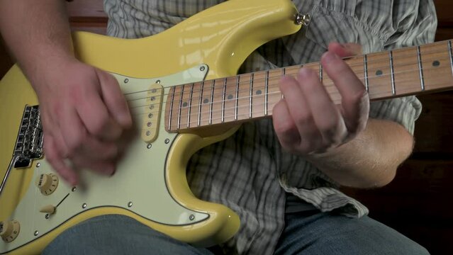 Man playing an yellow electric guitar. 4k video footage UHD 3840x2160