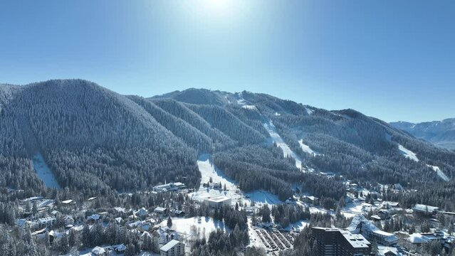 4k Aerial video of Poiana Brasov ski resort in Romania, next to Bucegi Mountains, win a beautiful winter landscape. Beautiful snowy day in Romania