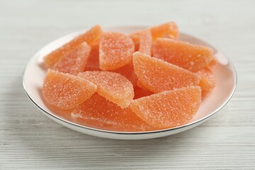 Tasty orange jelly candies on white table, closeup