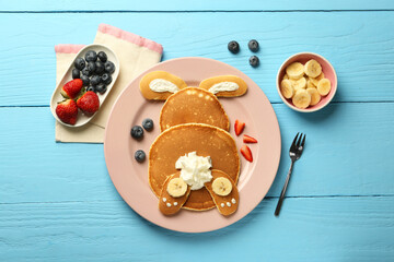 Creative serving for kids. Plate with cute bunny made of pancakes, berries, cream and banana on...