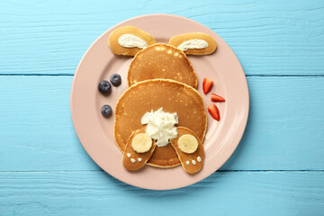 Creative serving for kids. Plate with cute bunny made of pancakes, berries, cream and banana on...