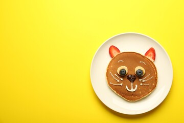 Creative serving for kids. Plate with cute cat made of pancakes, berries, cream, banana and...