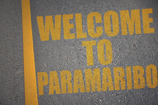 asphalt road with text welcome to paramaribo near yellow line.