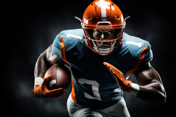 Portrait of American football player running with the ball. Muscular athlete in a blue and orange uniform with an ovoid ball in a dynamic pose. Isolated on black background. - obrazy, fototapety, plakaty