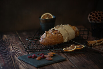 whole loaf of bread with cranberries and nuts on dark background 
