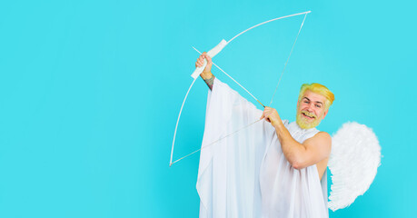Valentines Day. Male Valentine angel shoots arrow of love. Smiling bearded man in angel costume...