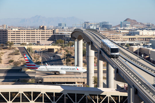 PHX Sky Train on rail bridge above an American Airlines Boeing 737 at Phoenix Sky Harbor International Airport - Phoenix, Arizona, USA