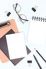 Black colored school supplies on a blue background. Empty notepad.