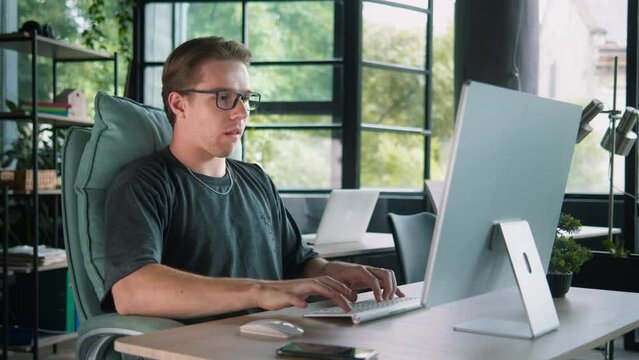 In the light-flooded workspace, a man exudes a sense of accomplishment as he achives result, his gesture of triumph reflecting a breakthrough moment