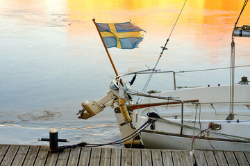 Tattered flag of Sweden. Flag on a yacht in winter.