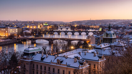 Ausblick über das winterliche Prag und die Moldau bei Sonnenuntergang im warmen Winterlicht - 715957539